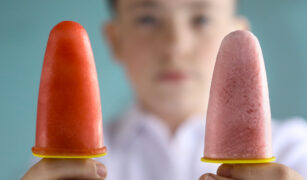 Doua înghetate de casa de fructe tinute in mana de un copil