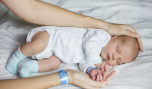 Baietel nou nascut mangaiat de mama lui - ambii poartă bratara cu numele