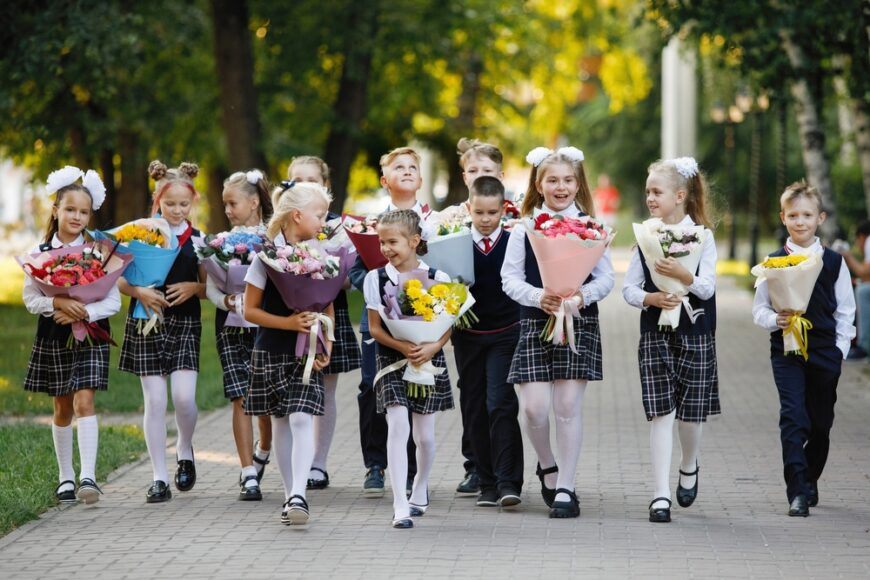 elevi ducând flori la început de an școlar