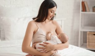 Bebelus alaptat la san de catre mama lui