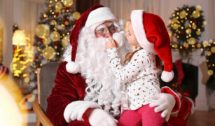 copil care sta in bratele lui mos craciun si il atinge pe nas