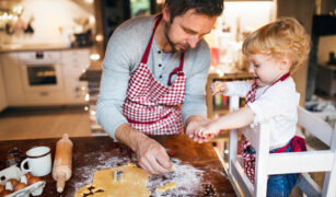 Copil si tatic decupeaza forme din aluat de turta dulce