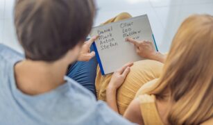 cuplu care se uita la o lista cu nume de baieti la moda