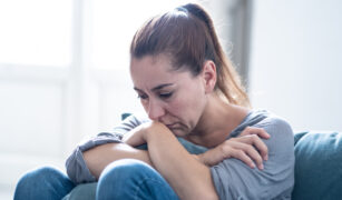 mama trista cu capul pe genunchi