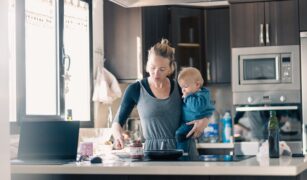 mama ocupata in bucatarie cu un copil in brate